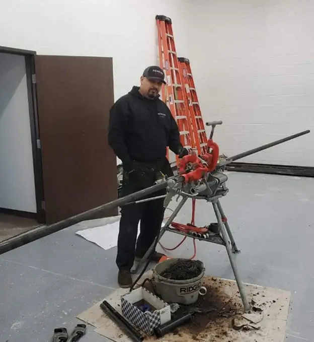 Nemesis Fire technician with pipe threading equipment